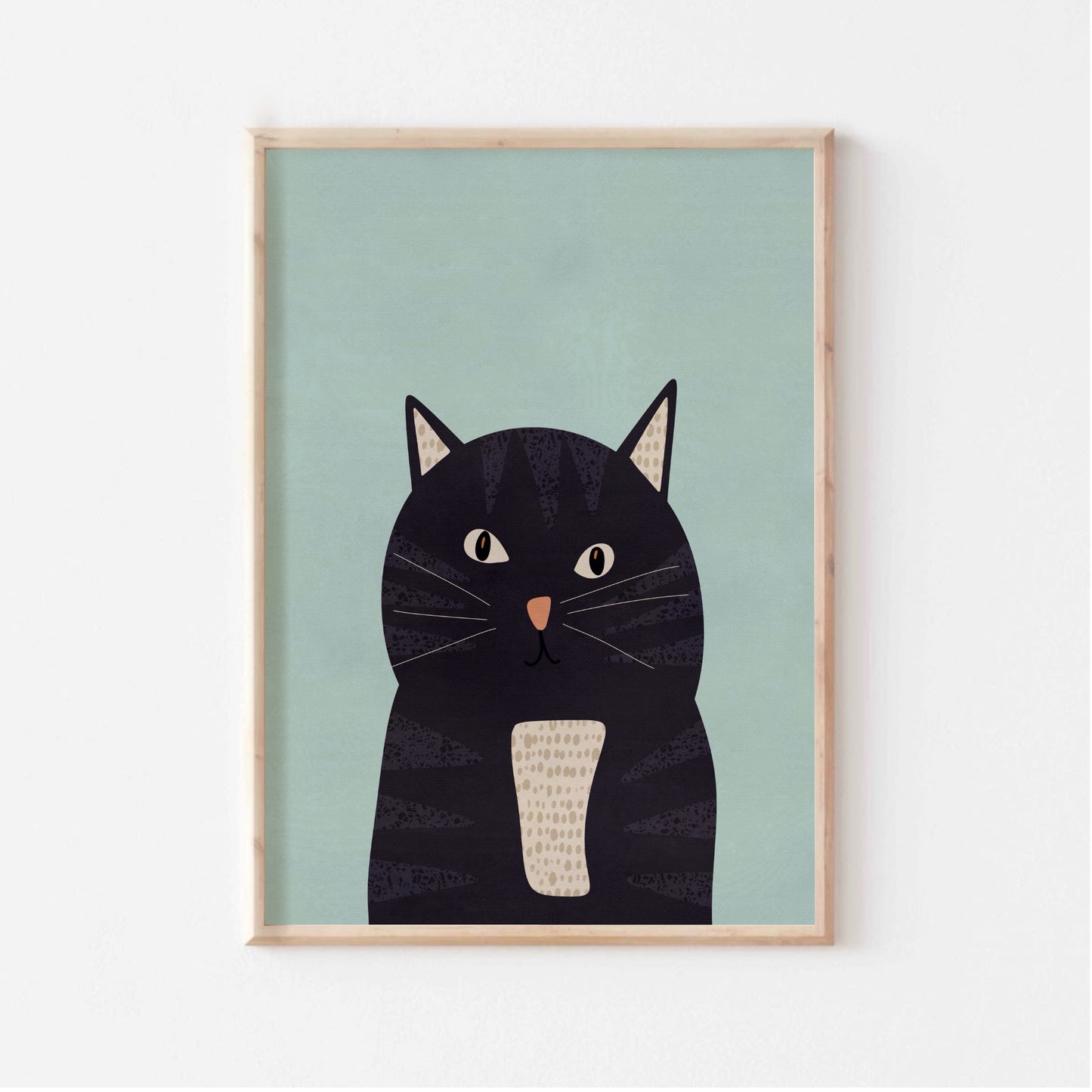 Kattposter i ljus träram uppsatt på en ljus vägg