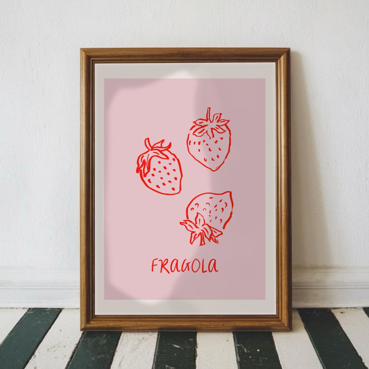Rosa jordgubbsposter Fragola inramad i mörk ram på randigt golv - modern väggkonst