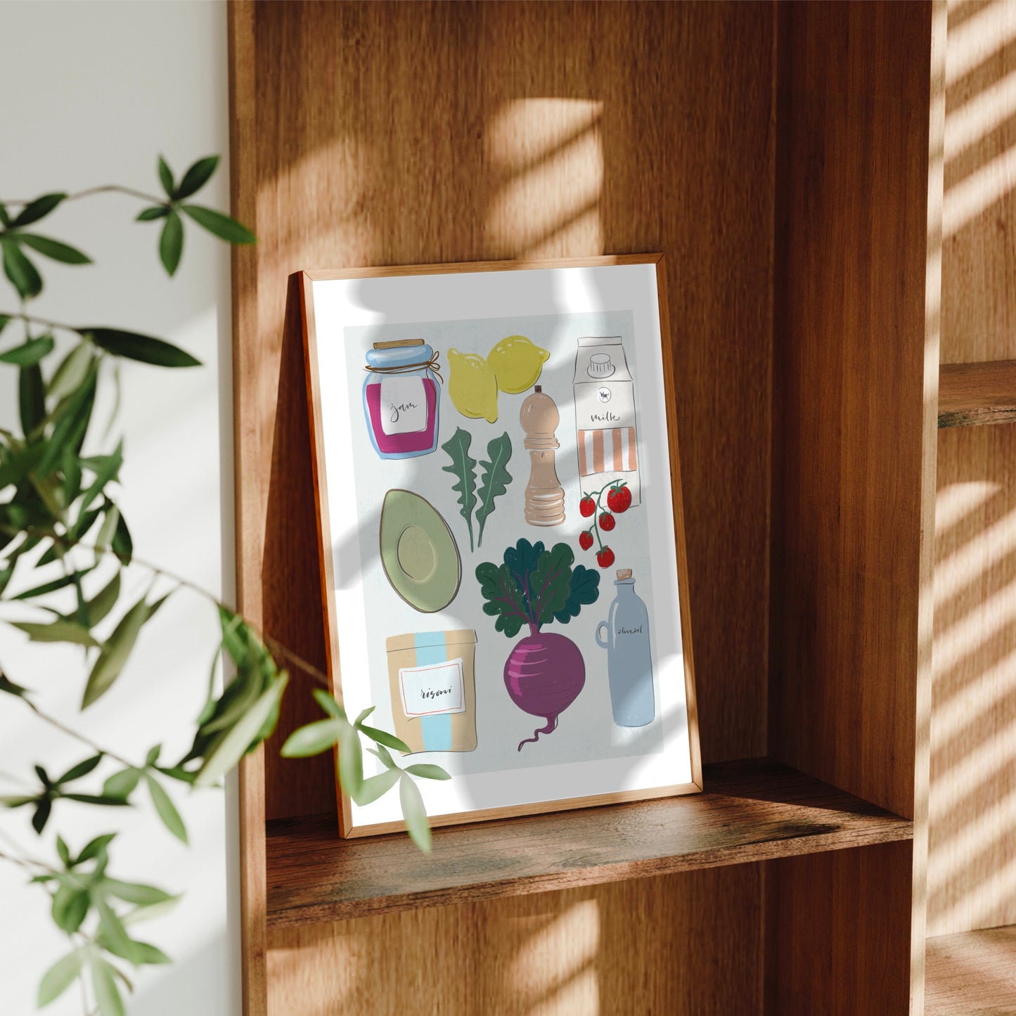 Handritad kökstavla Kitchen Favorites i träram placerad i en stilren trähylla med vackra ljusinsläpp och skuggor från ett fönster.