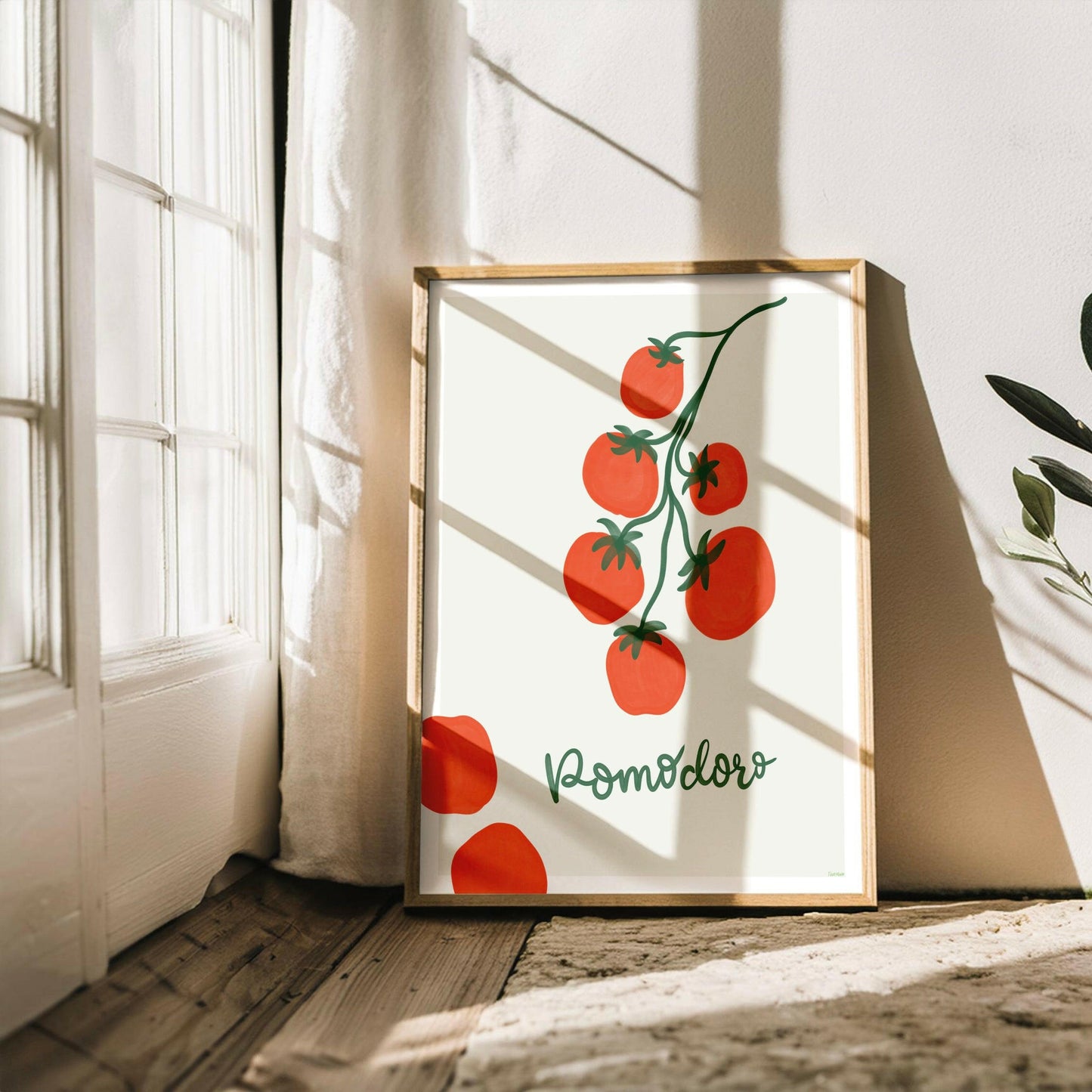 Pomodoro-postern inramad i en ljus träram lutandes mot en vit vägg med ljusinsläpp