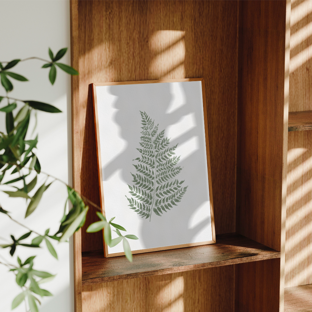 Modern väggdekor med botaniskt akvarellmotiv i dova gröna toner och naturfärgad ram.