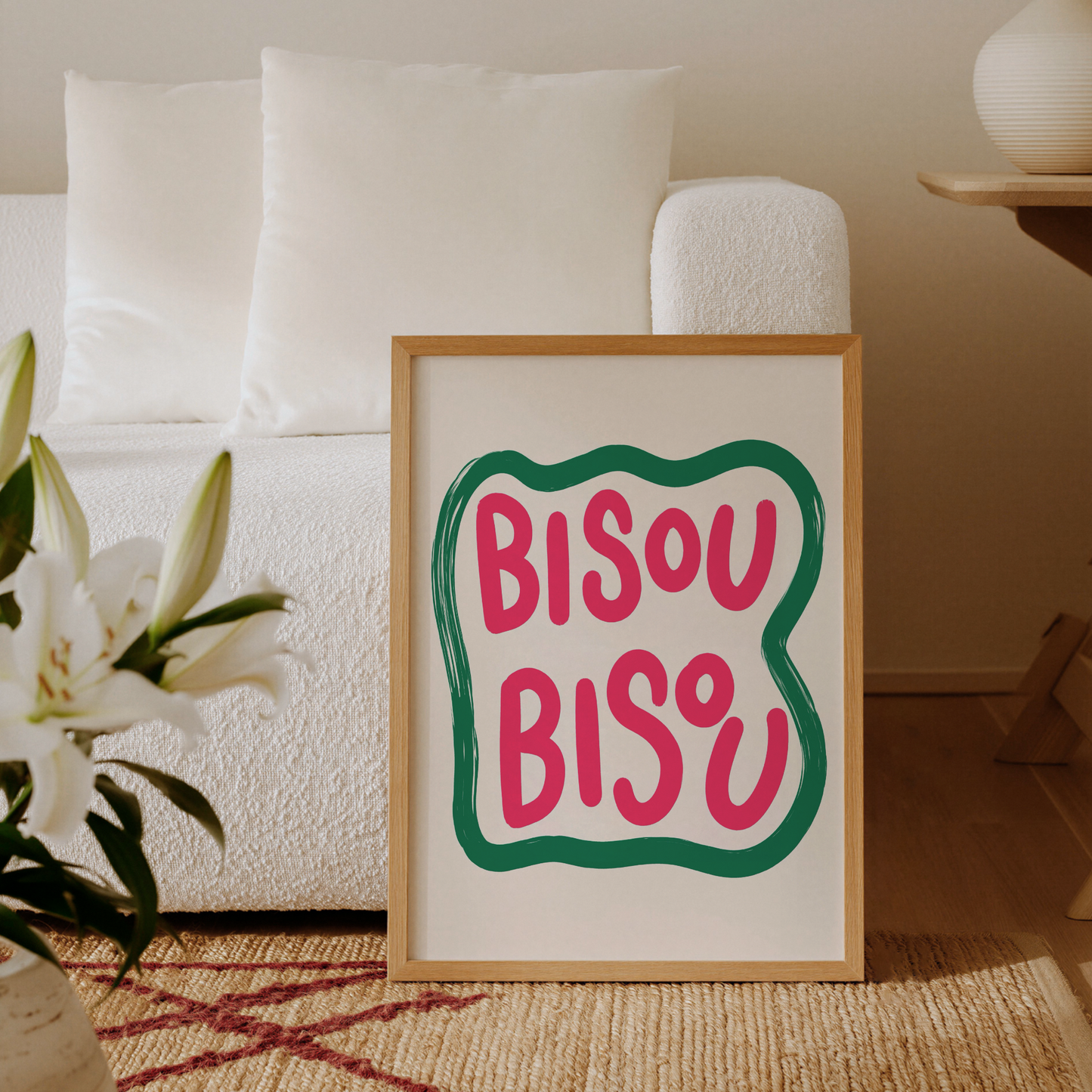 Bisou Bisou typografisk poster inramad och lutad mot en solbelyst kaklad vägg