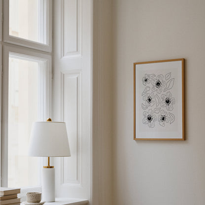 Grafisk vallmoposter upphängd i hall vid fönster med lampa