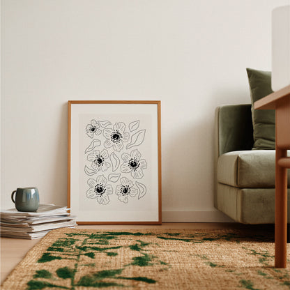 Grafisk vallmoposter lutad mot mörkgrön fåtölj med rustik matta