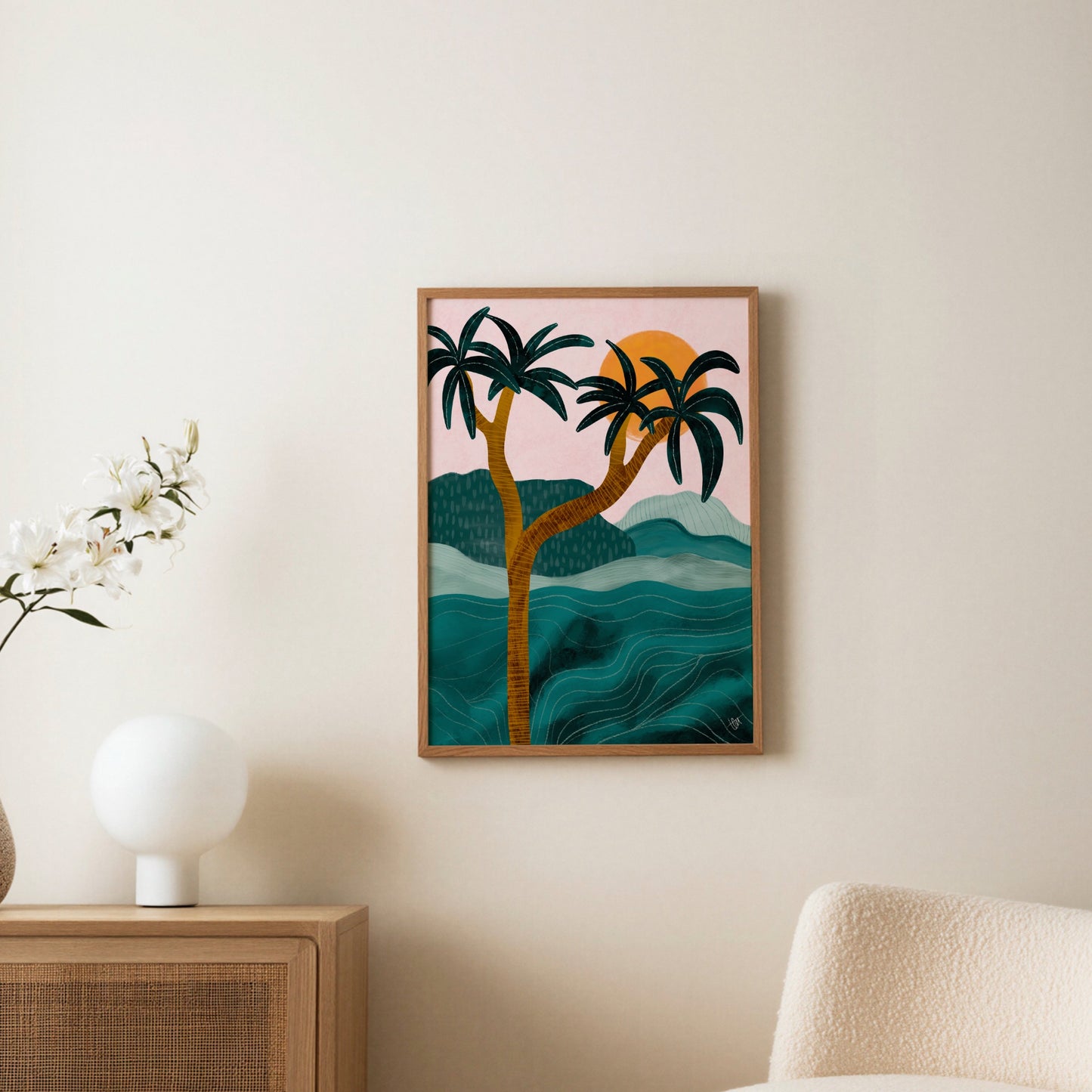 Palmposter i ljus träram uppsatt på vägg ovanför en byrå, med bordslampa och torkade blommor i rummet