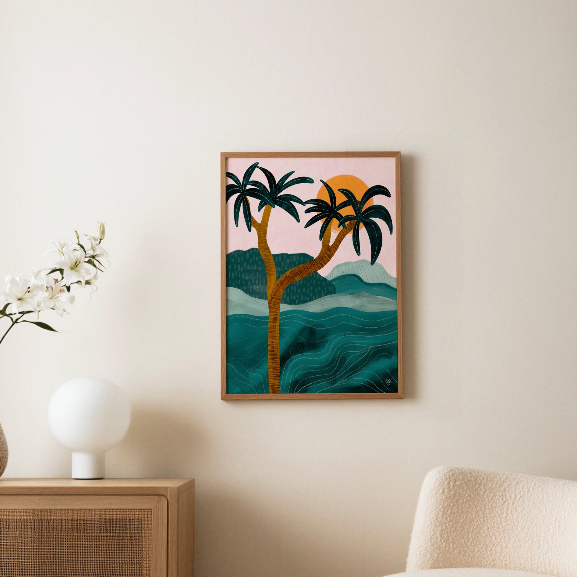 Palmposter i ljus träram uppsatt på vägg ovanför en byrå, med bordslampa och torkade blommor i rummet