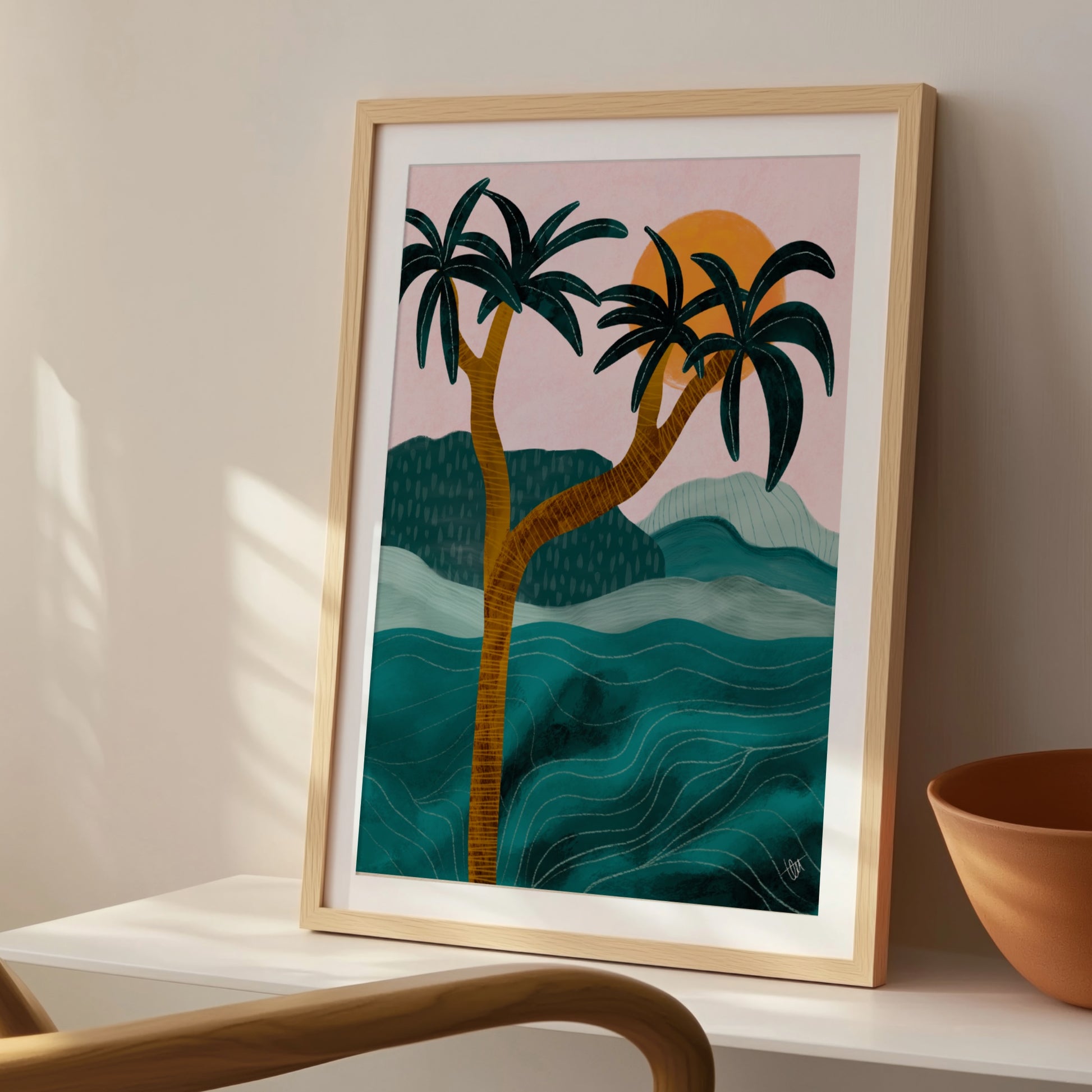 Palmposter i ljus träram placerad på en stol bredvid en flätad korg, för en avslappnad känsla i rummet