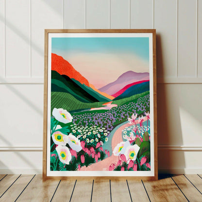 Kebnekaise-postern inramad i en ljus träram lutandes mot en vit trävägg i ett modernt vardagsrum med skandinavisk inredning. Visar hur motivet skapar en lugn och inspirerande känsla mot väggen.