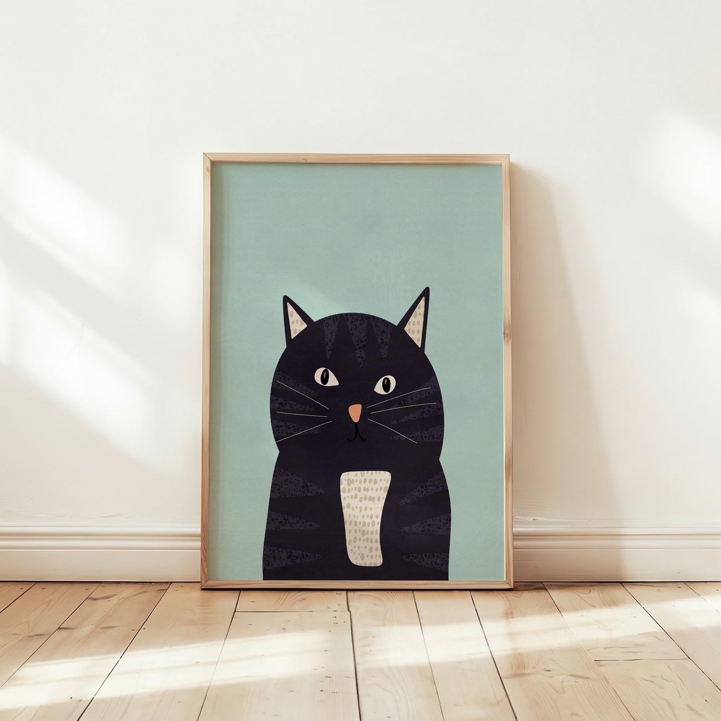 Kattposter i ljus träram på vägg i ett barnrum, med en bebis som leker på golvet i förgrunden