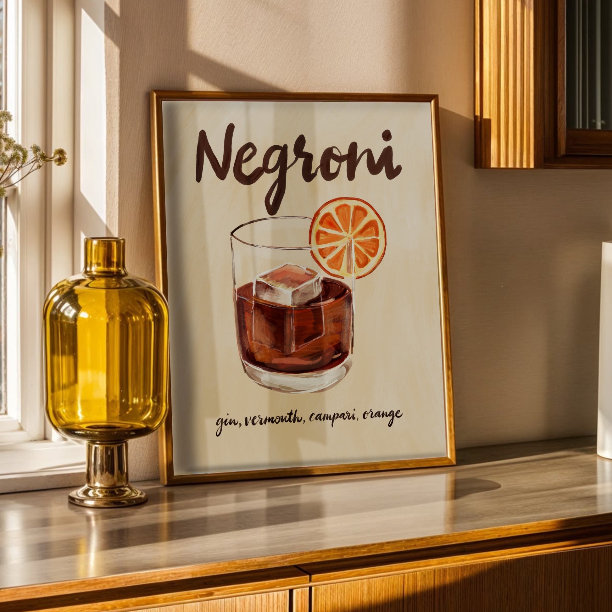 Negroni-poster i ram på träbord med gulddetaljer och minimalistisk inredning