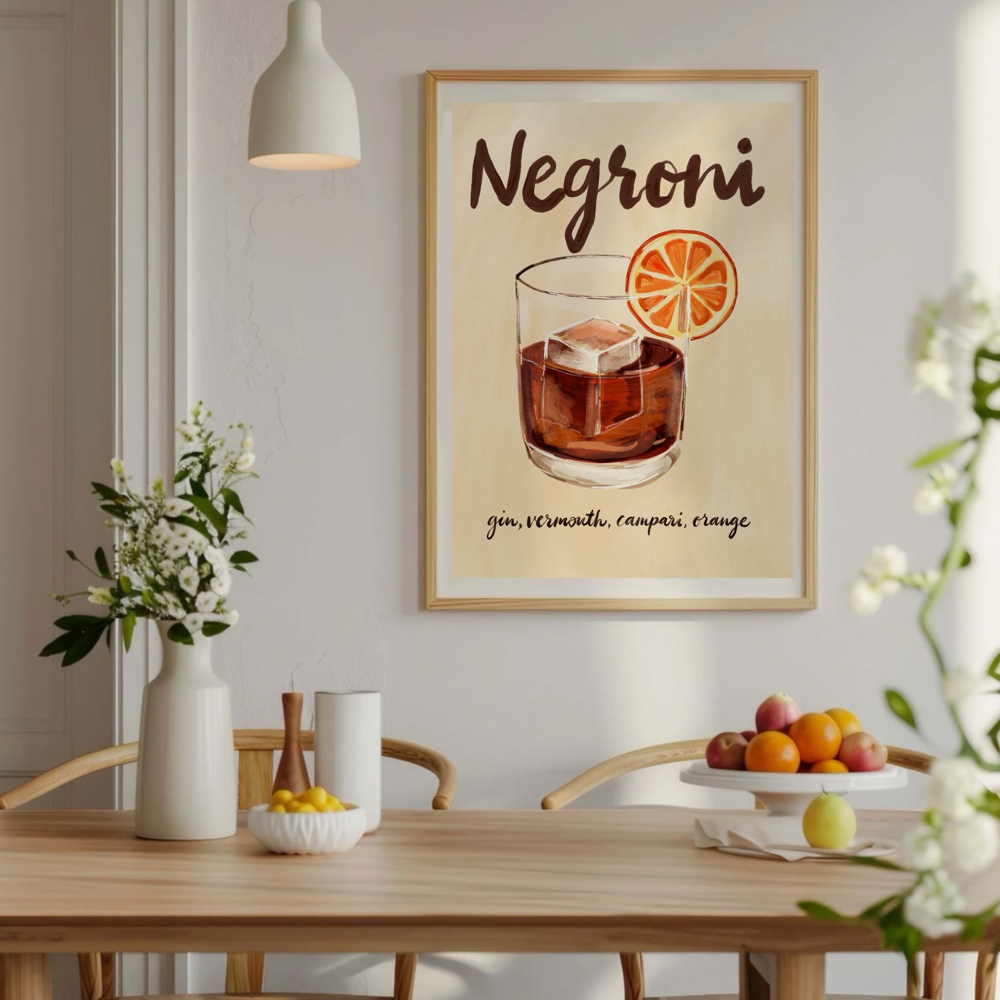 Negroni-poster inramad på ljus vägg ovanför ett träbord med växter i skandinavisk inredning