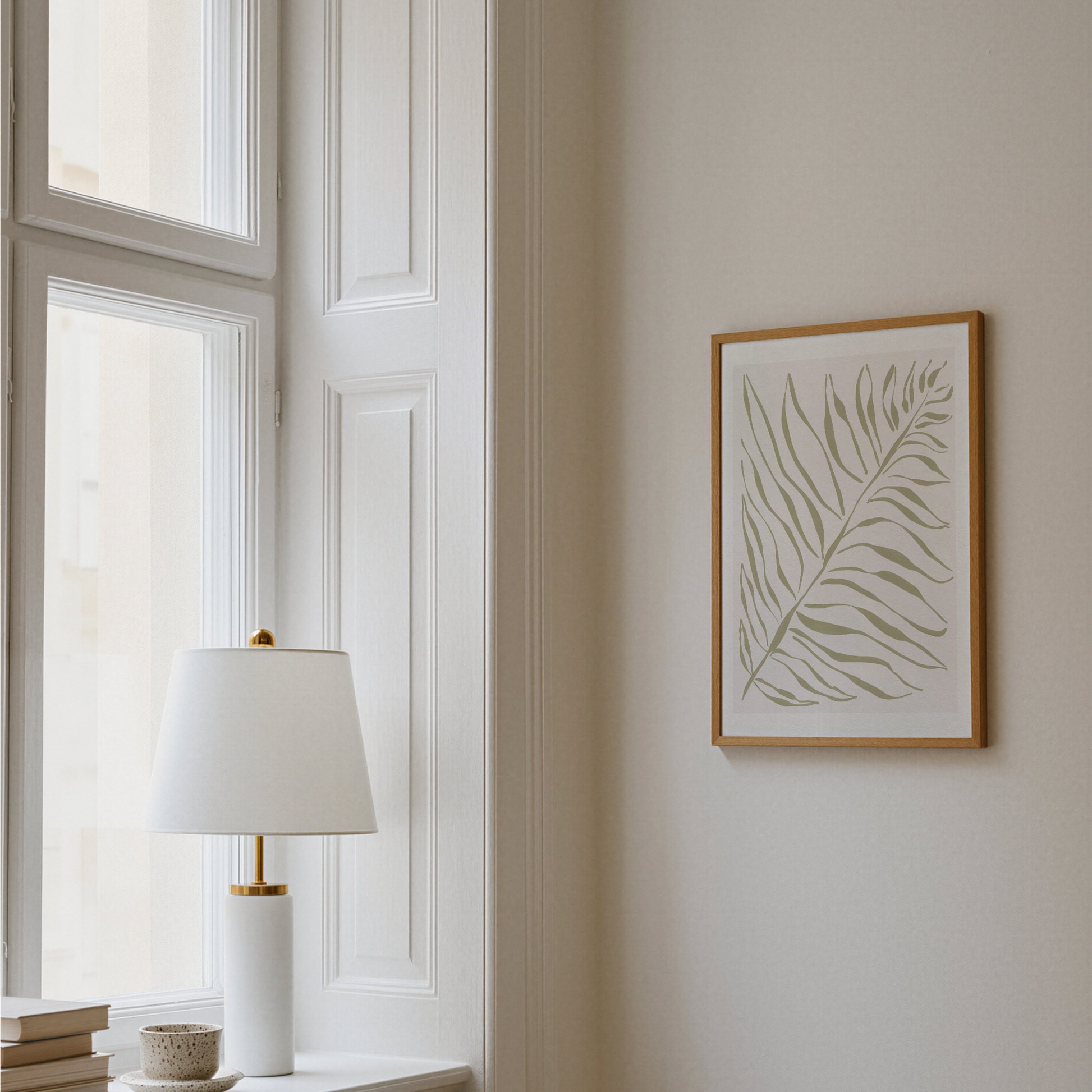 Akvarellposter med palmblad i olivgrönt, upphängd på vägg vid fönster
