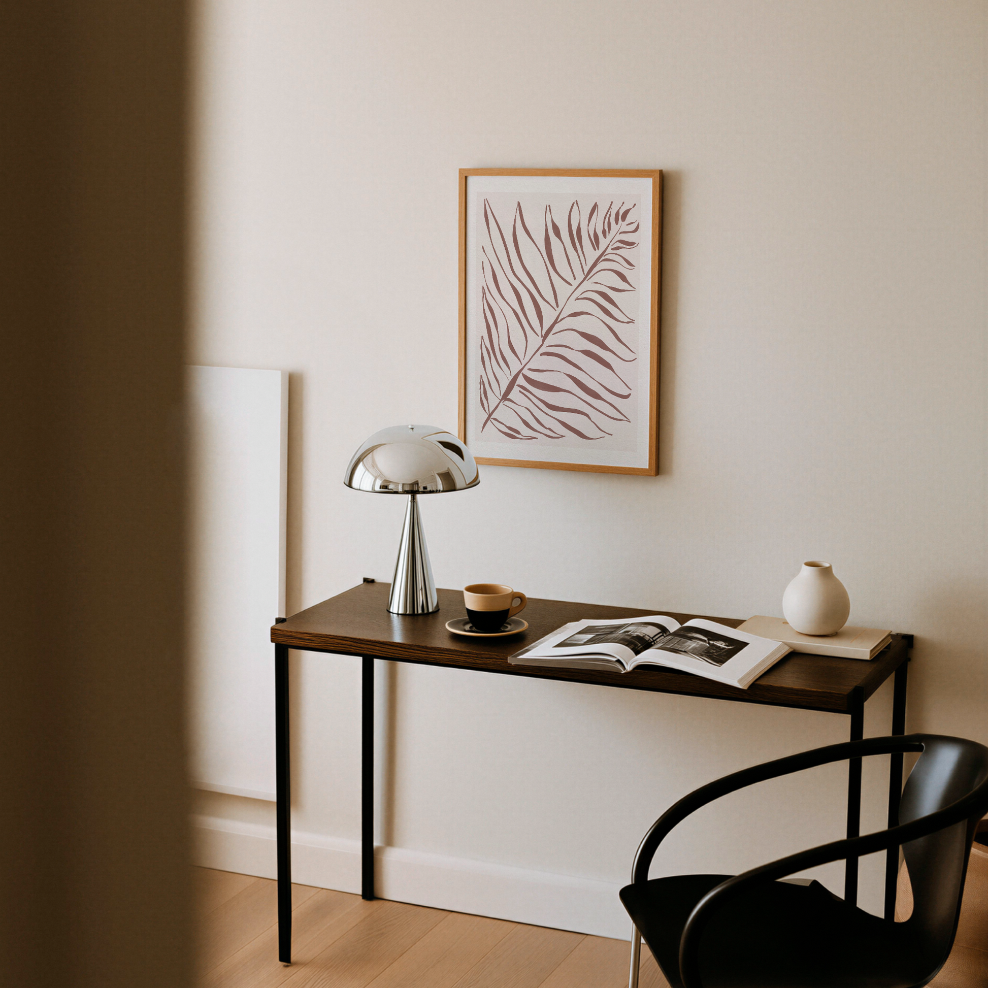 Akvarellposter med palmblad i terrakotta, upphängd ovanför avlastningsbord med lampa