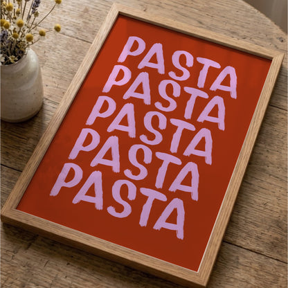 Pastaposter i ekram på ett träbord bredvid en vas med torkade blommor