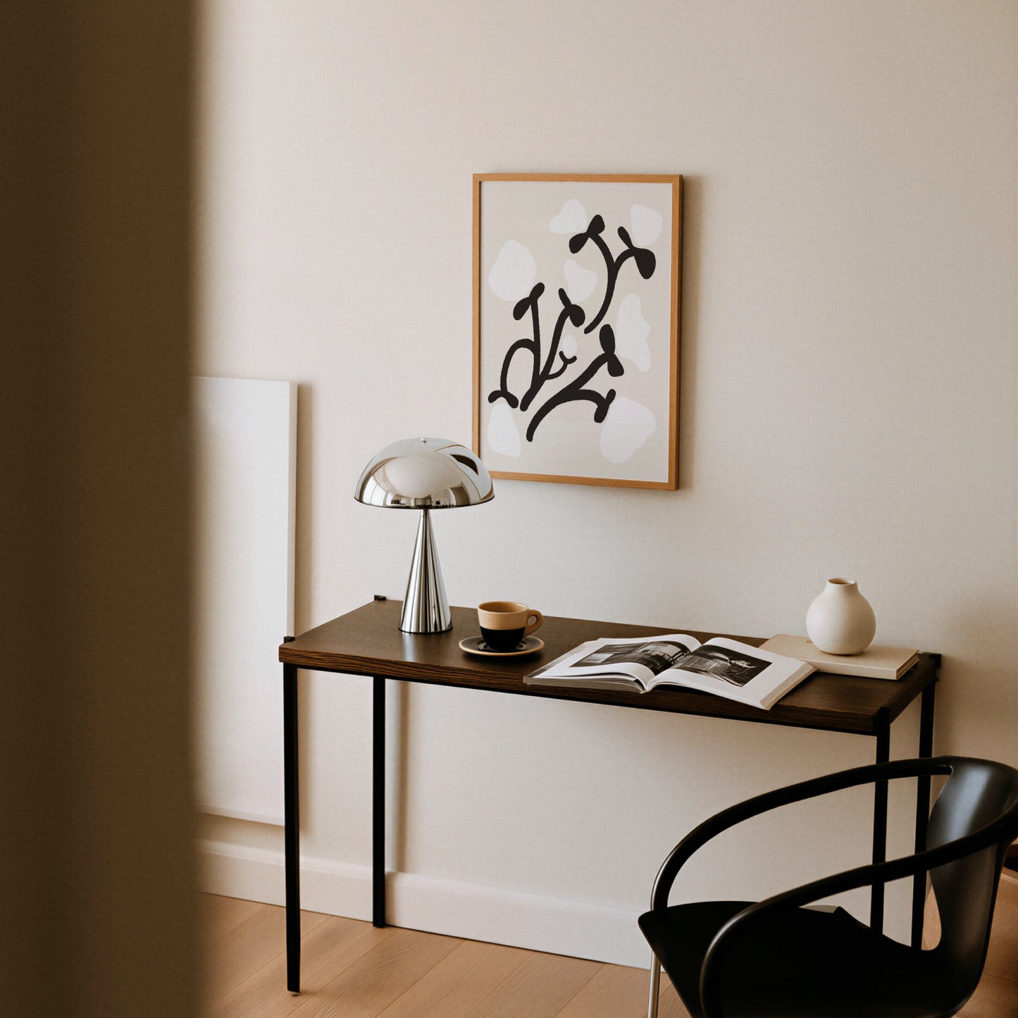 Grafisk pionposter upphängd ovanför skrivbord med lampa