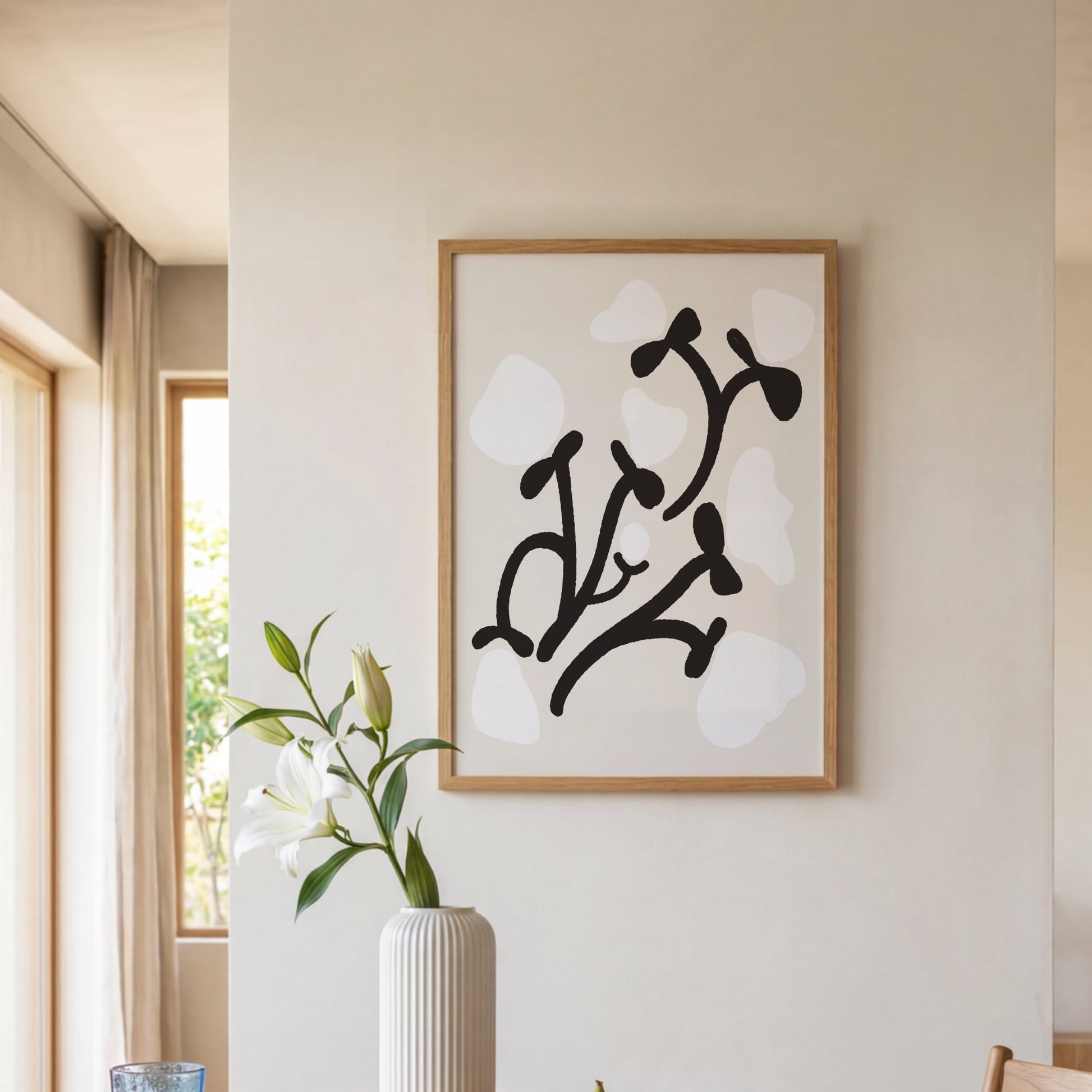 Grafisk pionposter upphängd vid fönster med blomvas