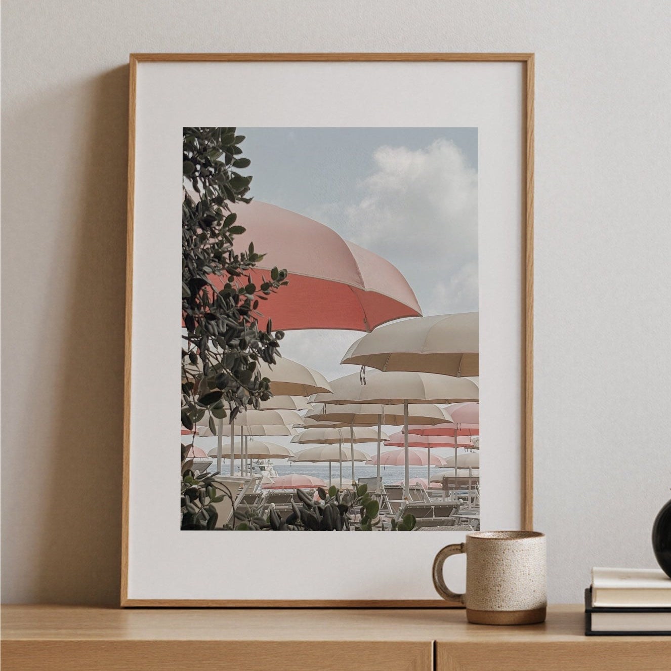 Fotokonst Pink Umbrella från Ligurien, på konsolbord med mugg och böcker