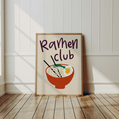 Nudelposter Ramen Club i aubergine på creme, lutad mot vägg på trägolv