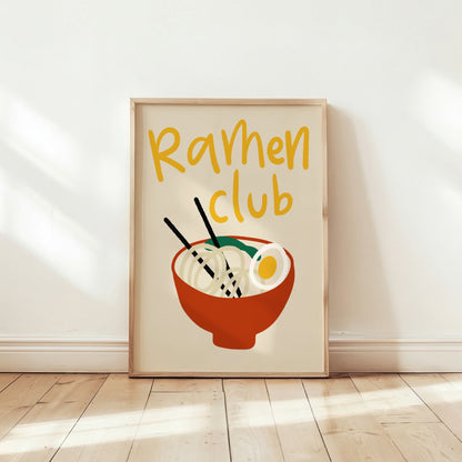 Ramenposter Ramen Club lutad mot vägg på trägolv i solljus