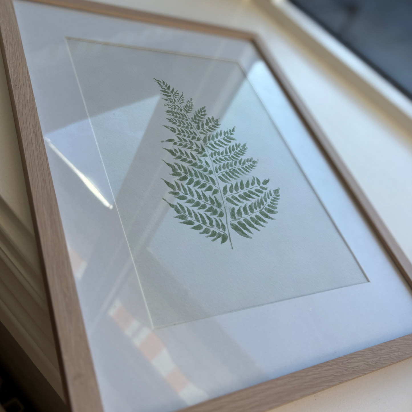 Konsttryck av en grön akvarell-ormbunke, tryckt på matt premiumpapper för en naturlig känsla.