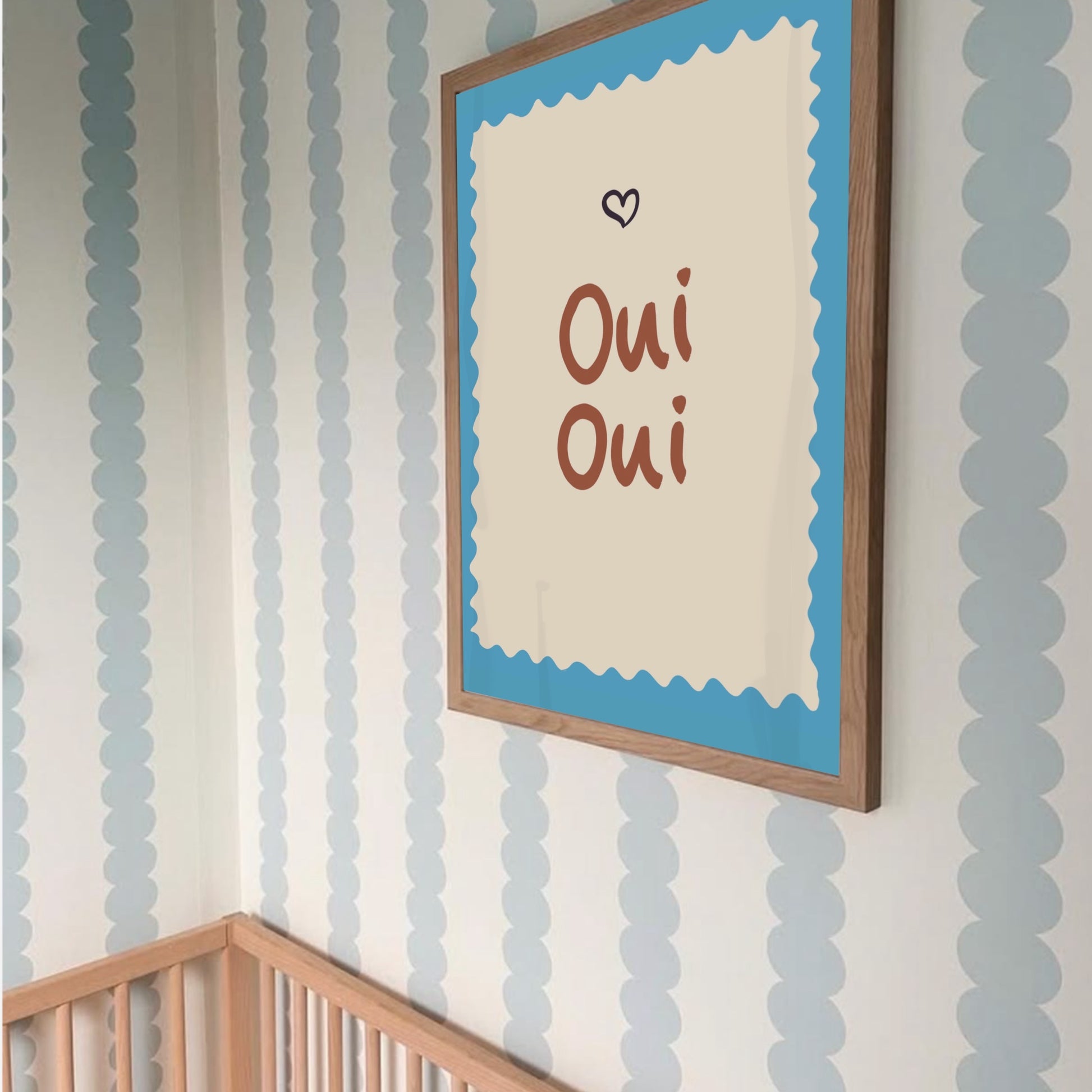 Lekfull barnrumsinredning med Oui Oui poster i terracotta-toner som en del av en personlig tavelvägg.