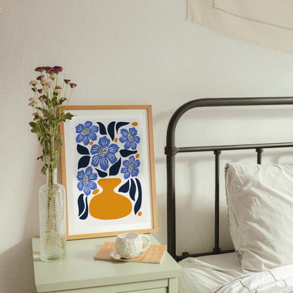 Den blå vallmopostern inramad i en ljus träram hängandes på en ljus vägg. Visar hur motivet fungerar som en sofistikerad och färgstark inredningsdetalj i ett skandinaviskt hem.