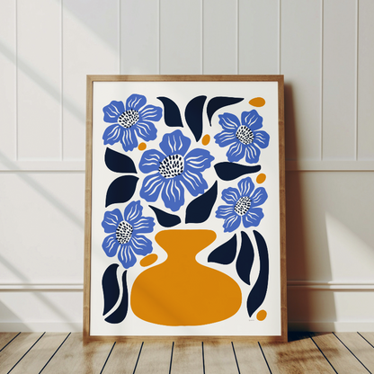 Närbild på vallmopostern som framhäver den  blå tonen med vallmo i gul vas, ram i trä lutande mot vit vägg