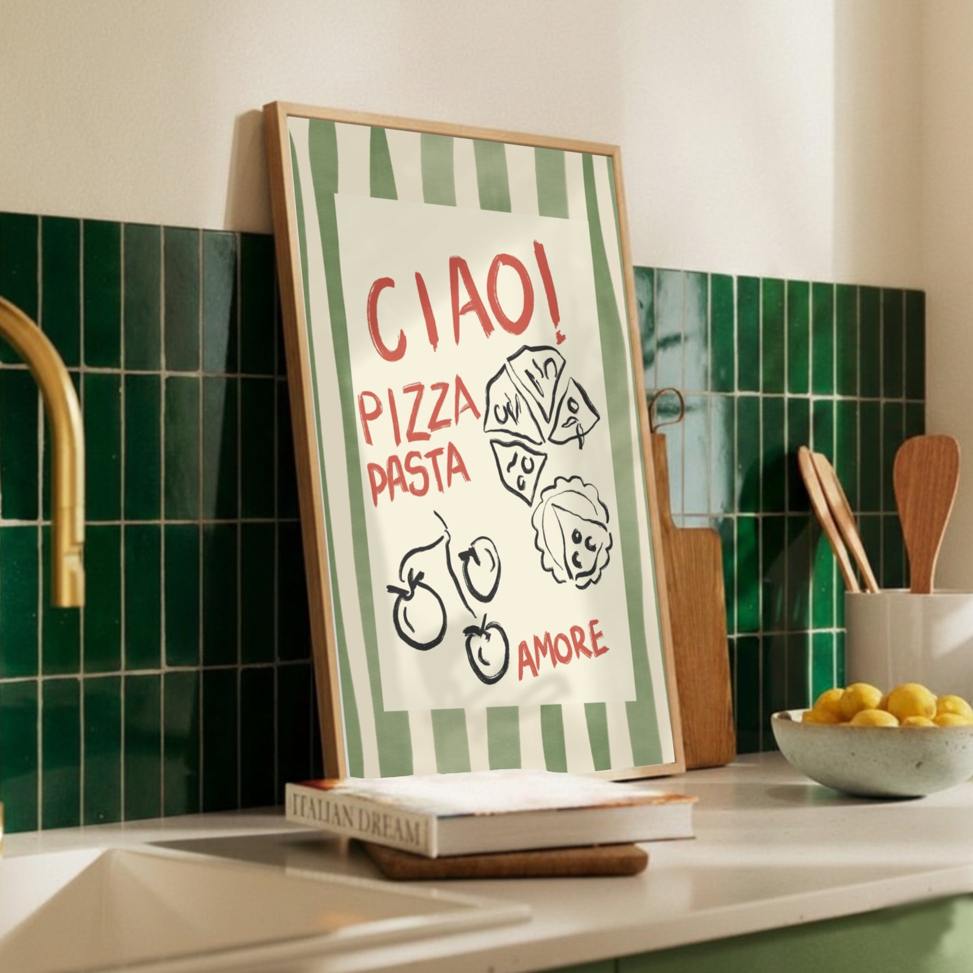 En handritad kökstavla med gröna vertikala ränder och texten Ciao Pizza Pasta Amore. Illustrationen sitter på en vägg i ett modernt kök med Scandi-Retro inredning och ger en personlig touch till matsalen.
