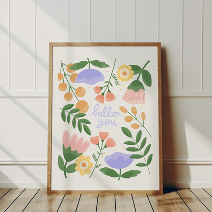 pastelliga blommor med inramad hello you skrivet i lila. trä ram i eftermiddagssol