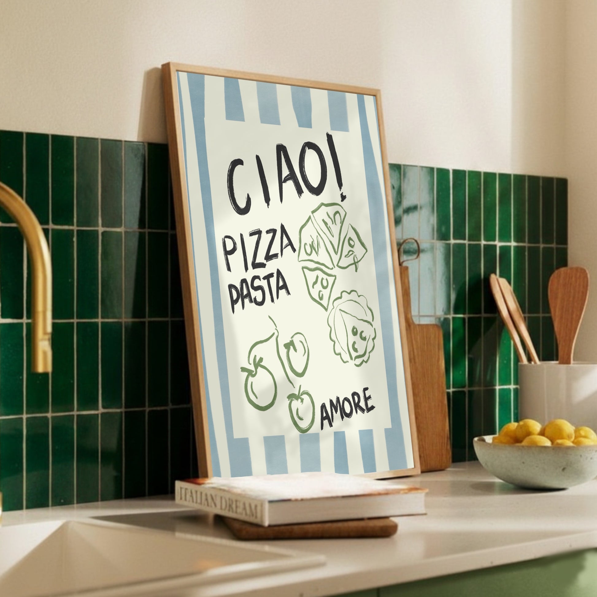 Inredningsdetaljer i kök med en handritad italiensk kökstavla lutad mot ett mörkgrönt kakel vid en diskho. Motivet visar 'Ciao Pizza Pasta Amore' med blå ränder, perfekt för en modern och personlig matsal.