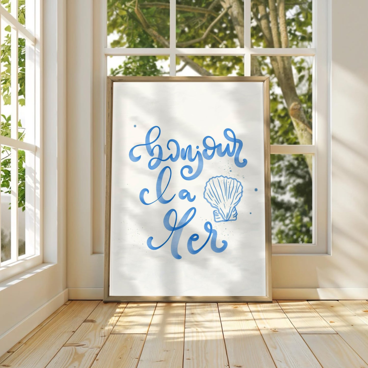 Bonjour la Mer-postern inramad i en ljus träram i ett ljust sovrum. Visar hur den blå akvarellkonsten skapar en lugnande och somrig atmosfär i inredningen.