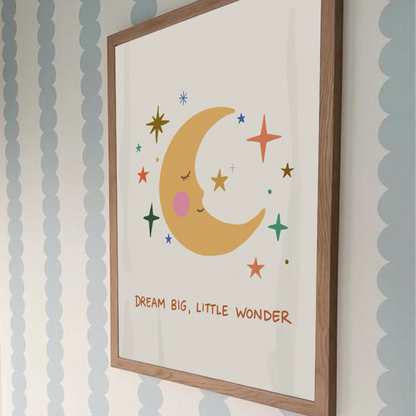 Detaljbild på en minimalistisk barnrumsposter med måne och stjärnor hängd mot en tapet med blå vågmönster.
