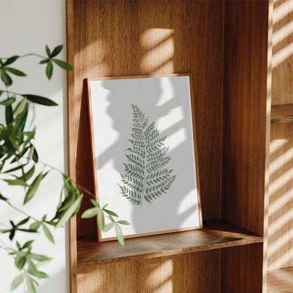 Modern väggdekor med botaniskt akvarellmotiv i dova gröna toner och naturfärgad ram.