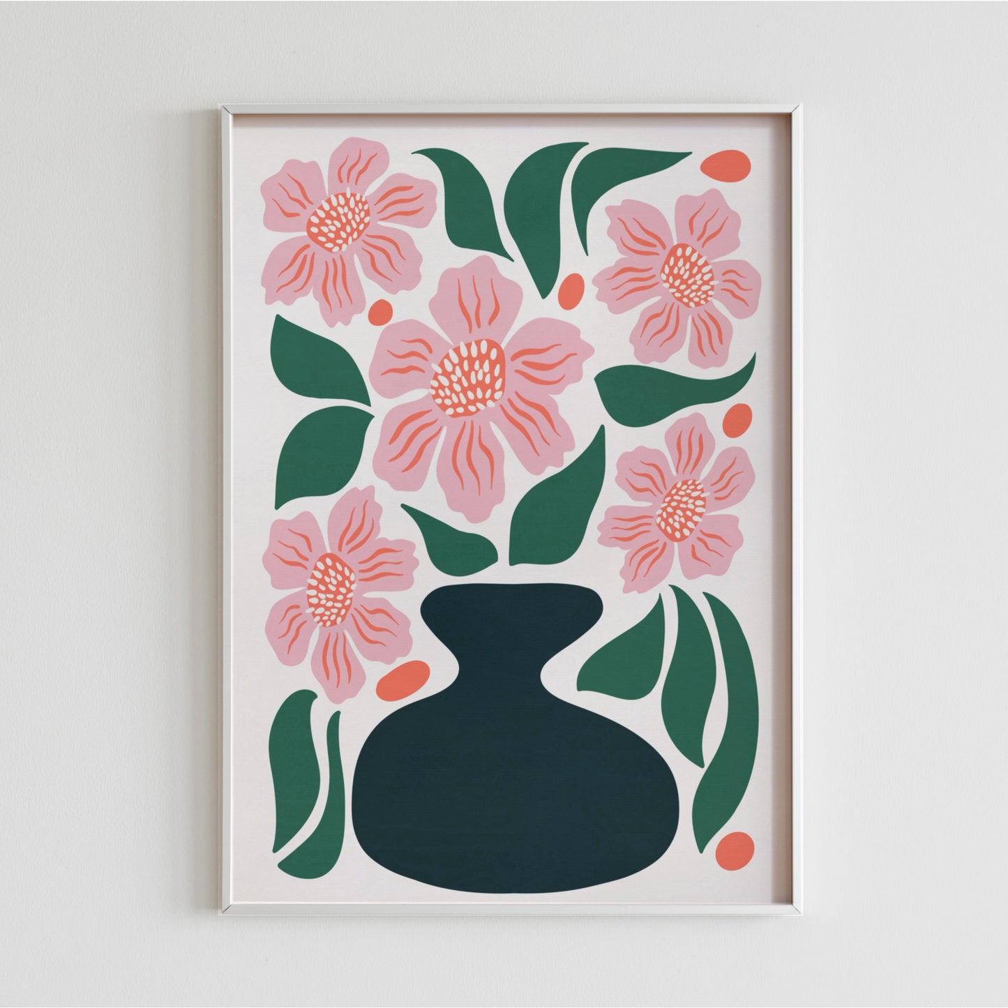 Närbild på en vitramad poster med rosa blommor och gröna blad monterad på en vit vägg. Elegant och stilren väggdekoration för ett modernt hem.