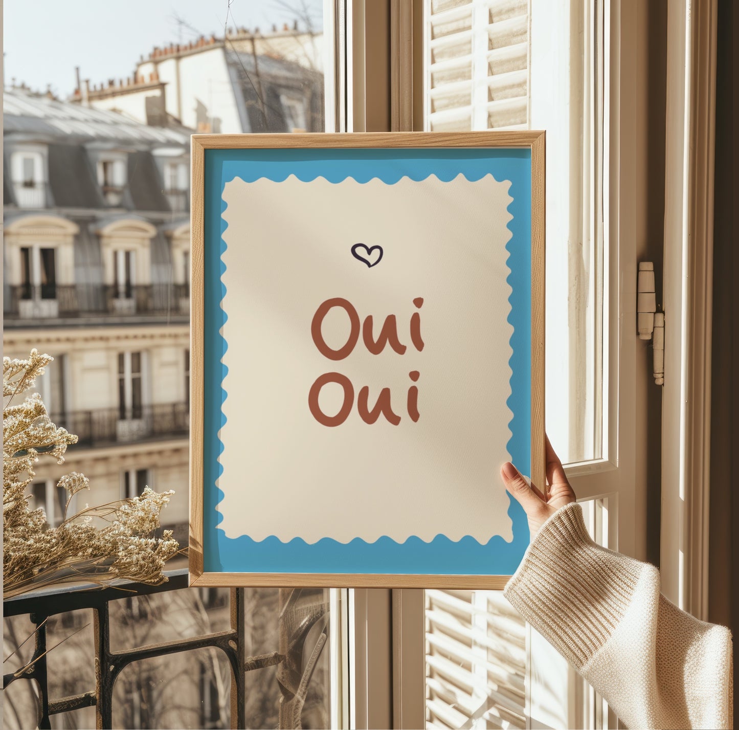 Inramad Oui Oui poster i terracotta och turkos placerad som ett stilleben, ett unikt presenttips för inredningsintresserade.