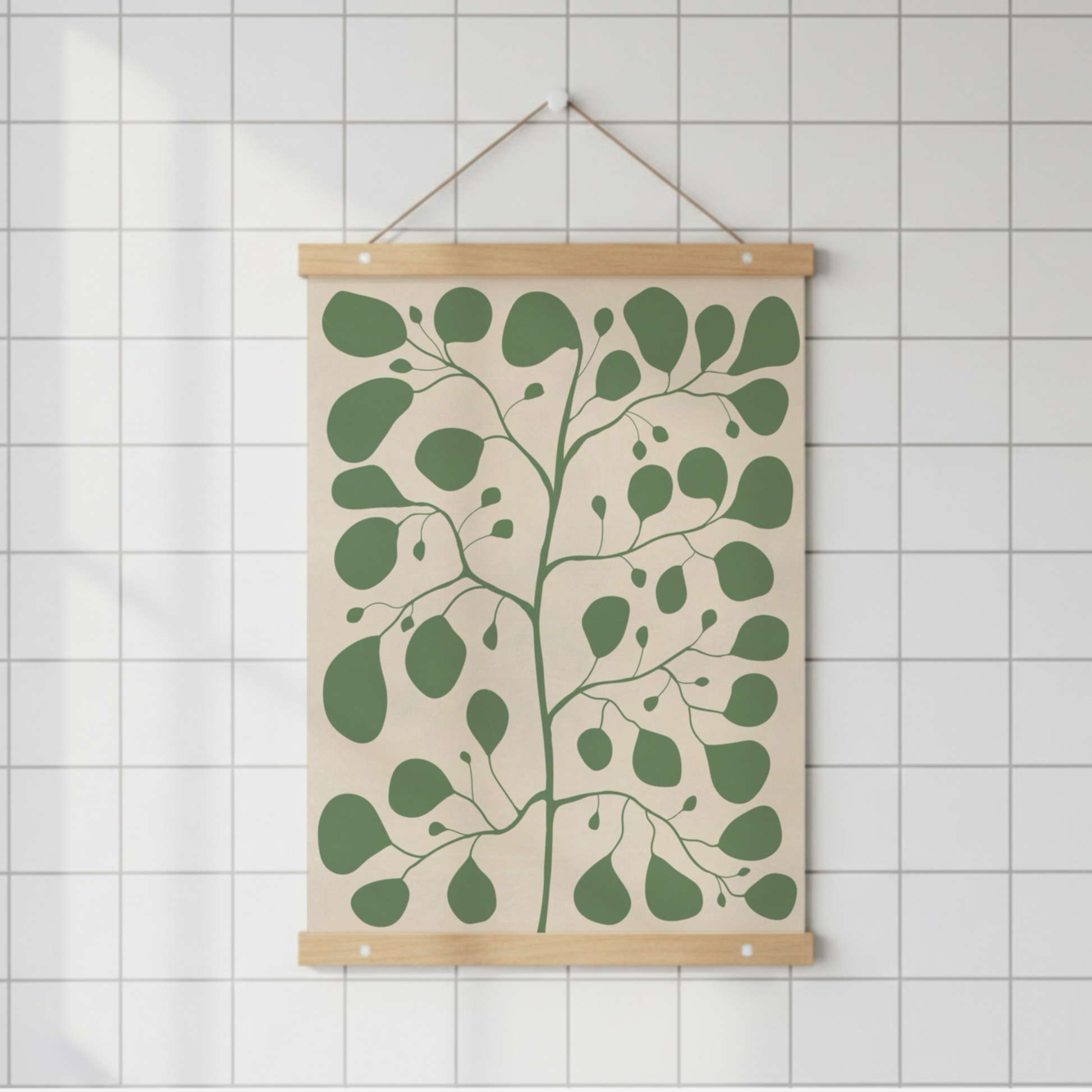Pilea-illustration upphängd med en magnetisk posterlist i trä på en vit kakelvägg. Enkel och ren design för den moderna minimalistiska inredningsstilen.