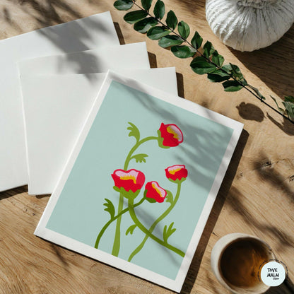 Flatlay på träbord med konsttryck av pioner, kaffekopp och gröna blad – botanisk väggkonst från Tove Malm.
