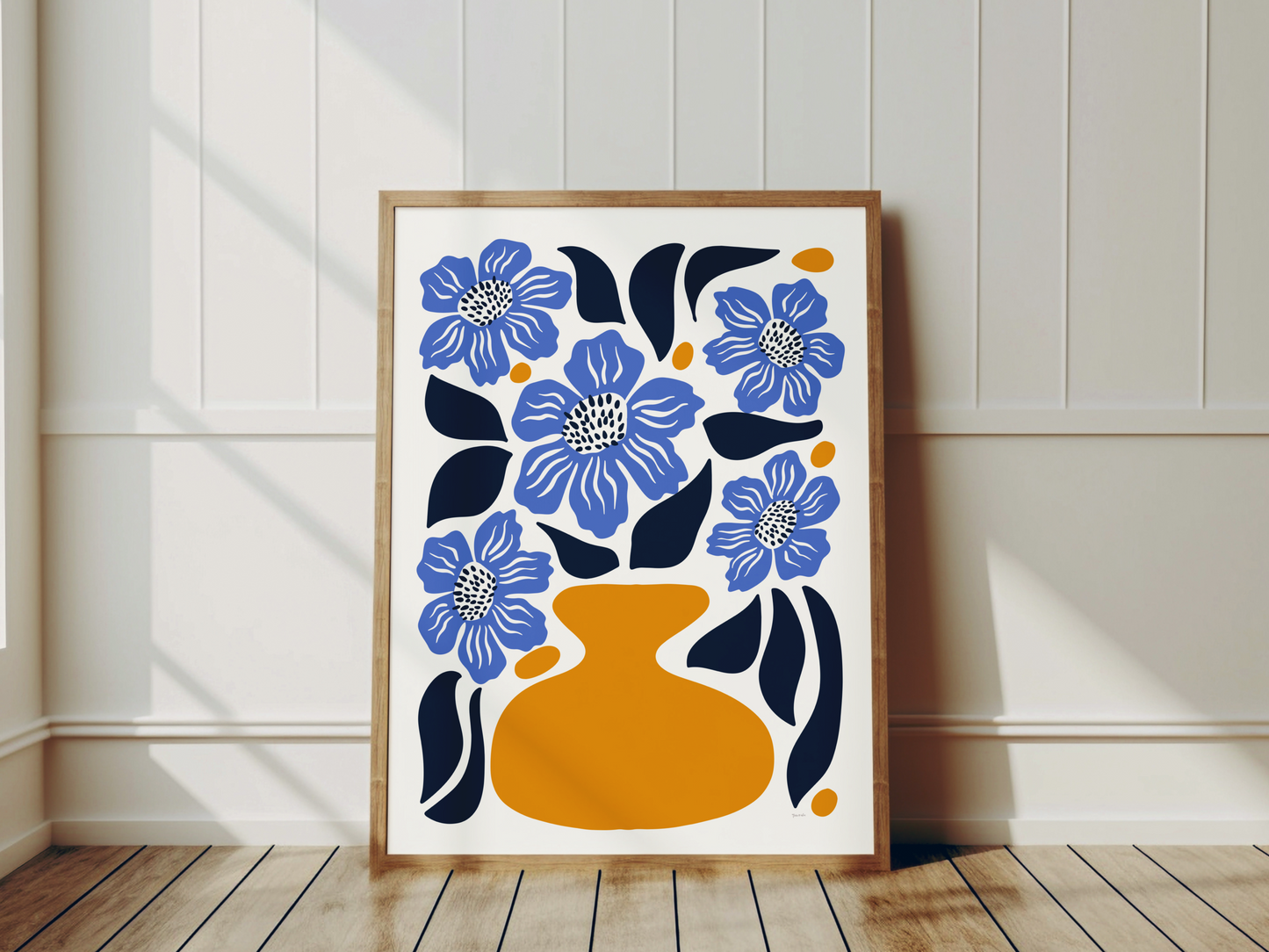 färgstark blå botanisk posterprint med vallmo i gul vas, ram i trä lutande mot vit vägg