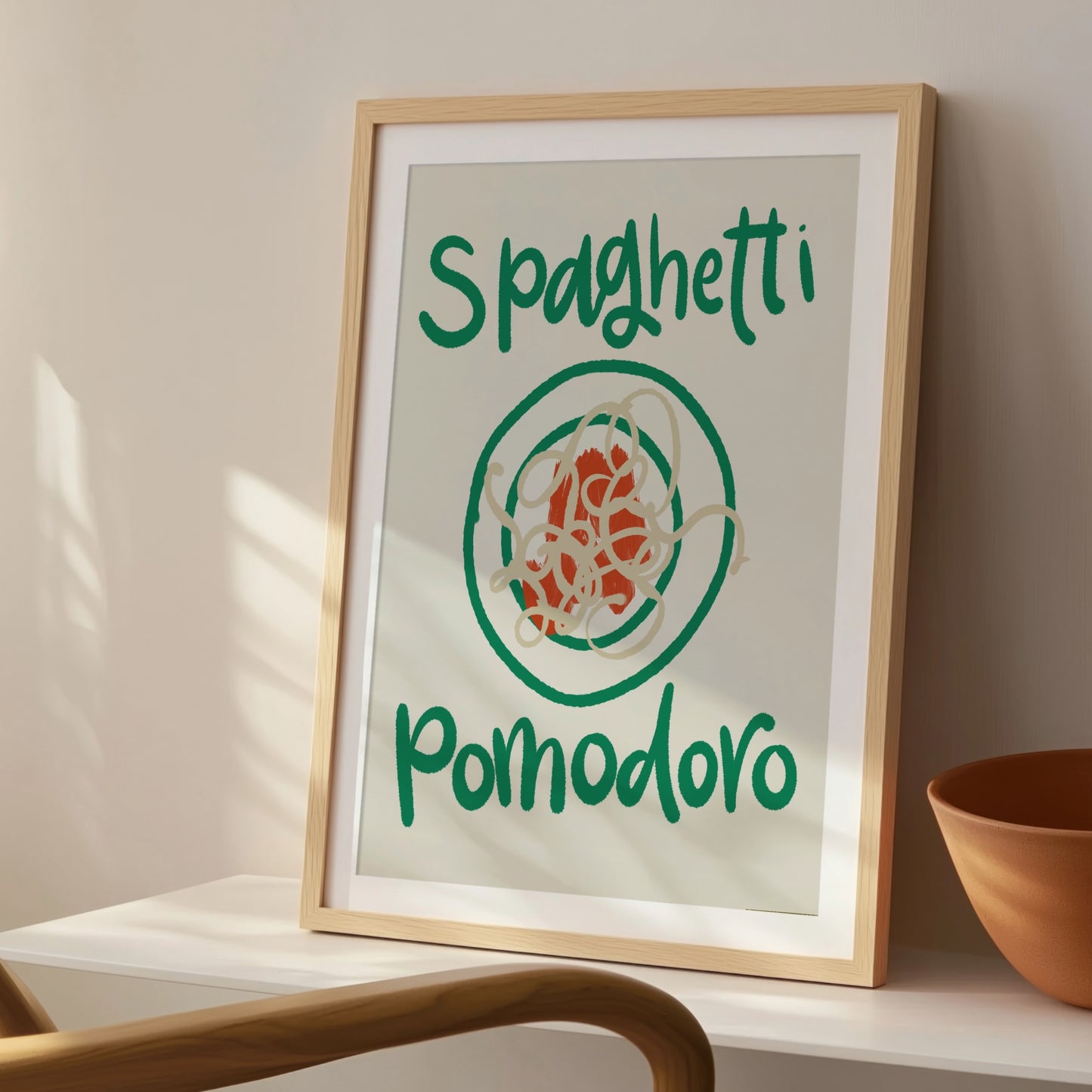 Pastaposter med handskriven text Spaghetti Pomodoro i grönt, på konsolbord i solljus