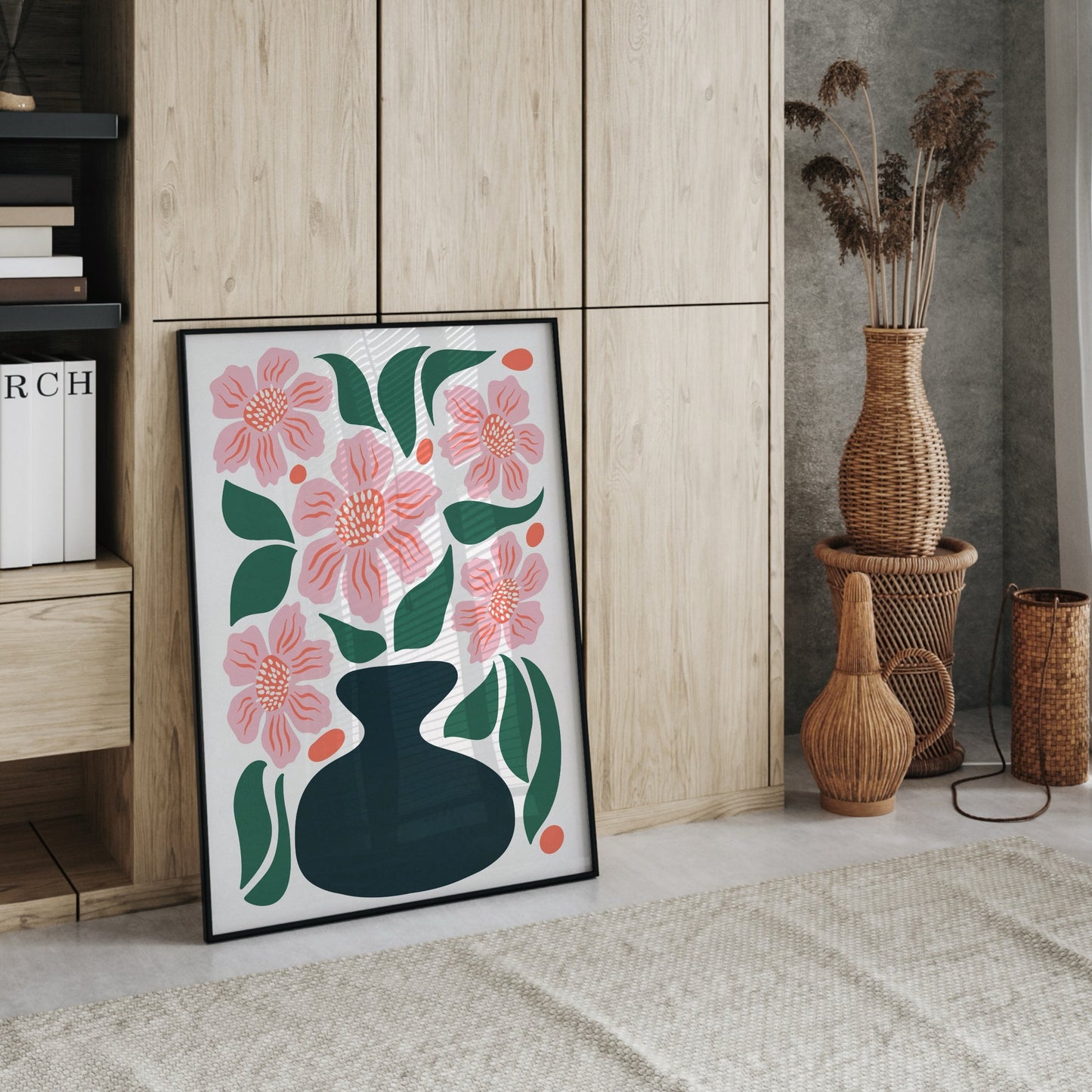 Stor inramad poster med blommotiv placerad på golvet i ett ljust rum med naturmaterial, flätade vaser och trämöbler. Bohemisk och varm inredningsstil från Tove Malm